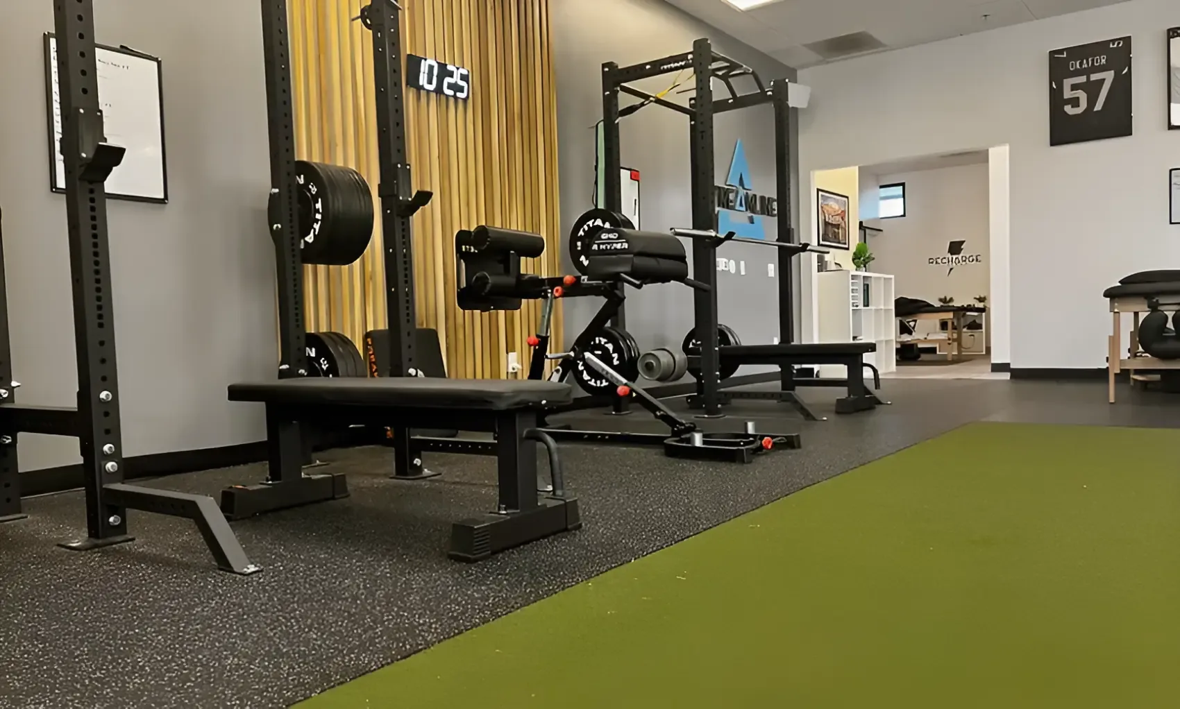 The gym floor at Streamline Performance Physical Therapy in Phoenix, AZ: power racks, bumper plates and a turf strip