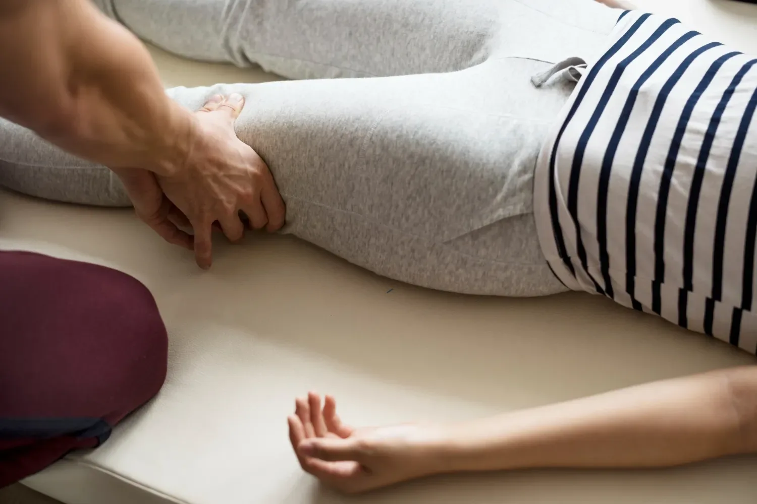 A clinician's hands working the lower abdomen of a patient lying supine at Streamline Performance Physical Therapy in Phoenix, AZ